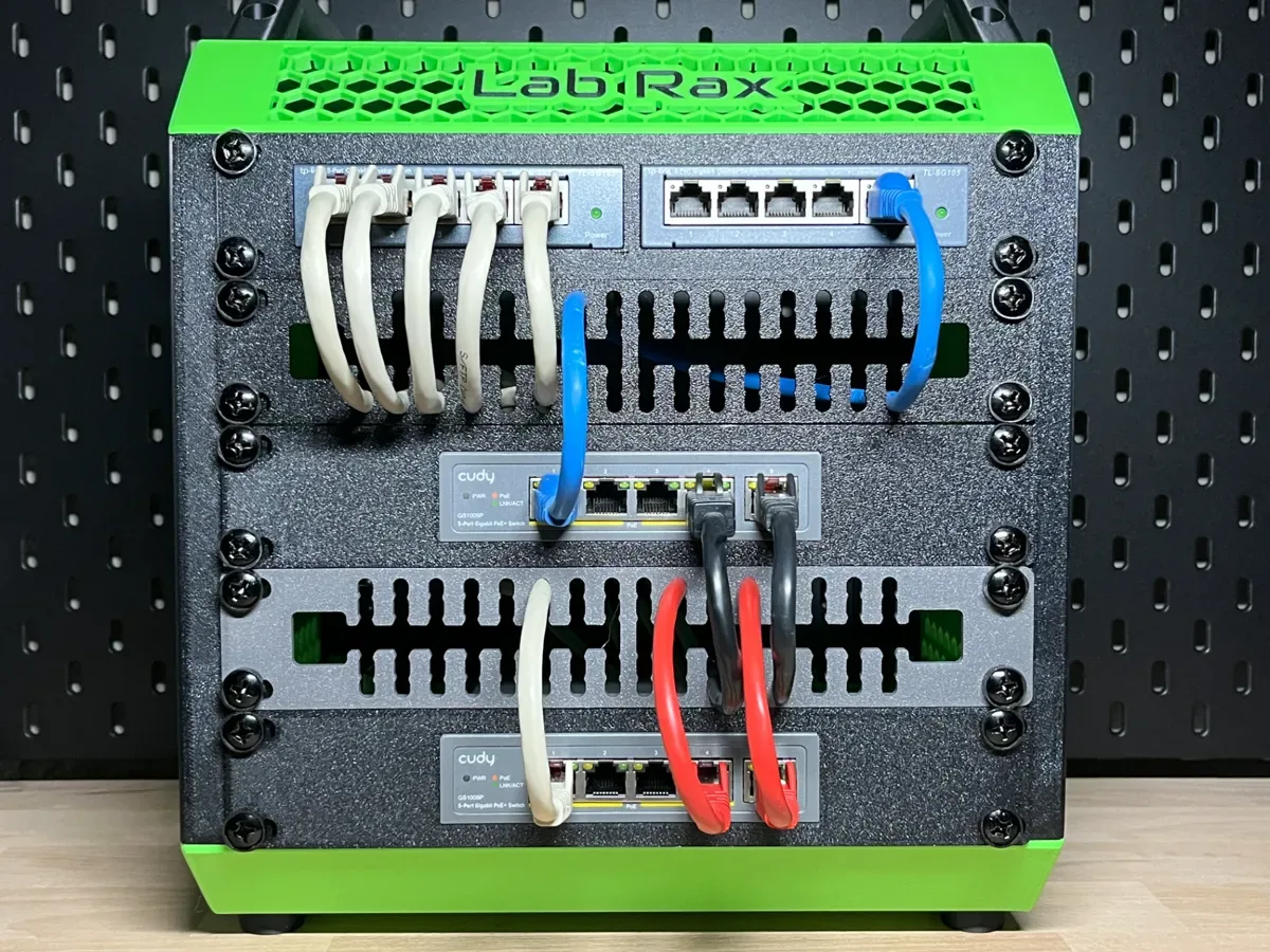 Das 10-Zoll-Rack von vorn: zwei Switches, ein Patchfeld und die schwarze Blende, durch die helle und blaue Patchkabel geführt sind