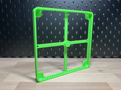 The same frame upright in front of the black pegboard, the slots in the side walls backlit
