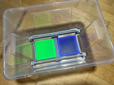 Von oben in die Samla-Kiste: eine grüne und eine blaue Box liegen nebeneinander unter dem grauen Spulenhalter